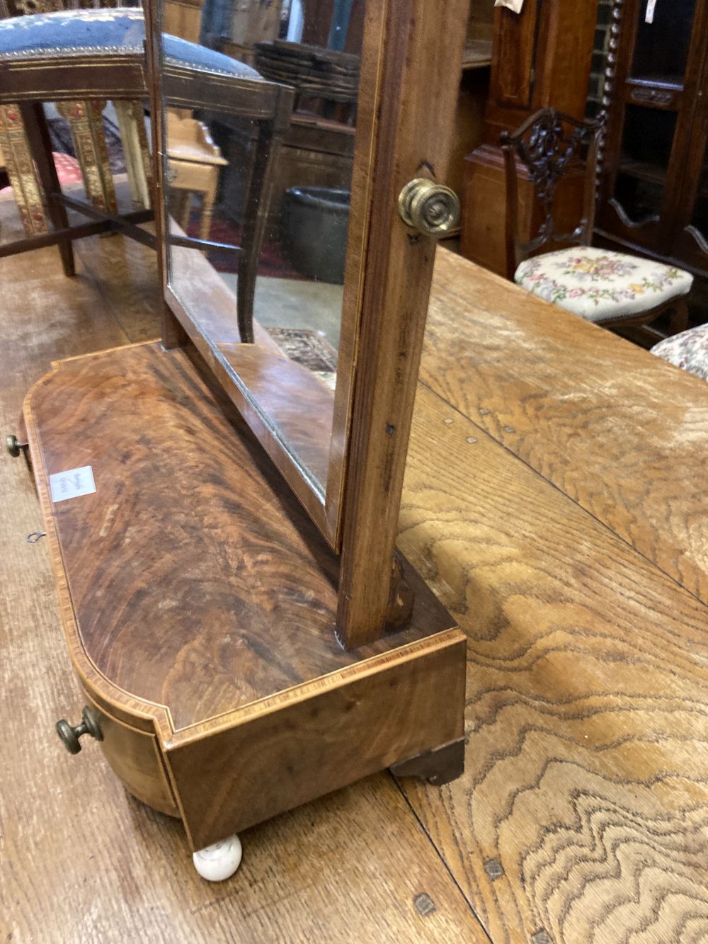 A George III mahogany and tulipwood banded bowfronted toilet mirror, on ivory ball feet, width 54cm depth 23cm height 60cm